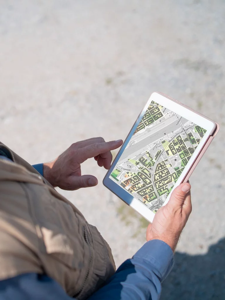 Mann mit Tablet auf dem eine Stadtkarte abgebildet ist